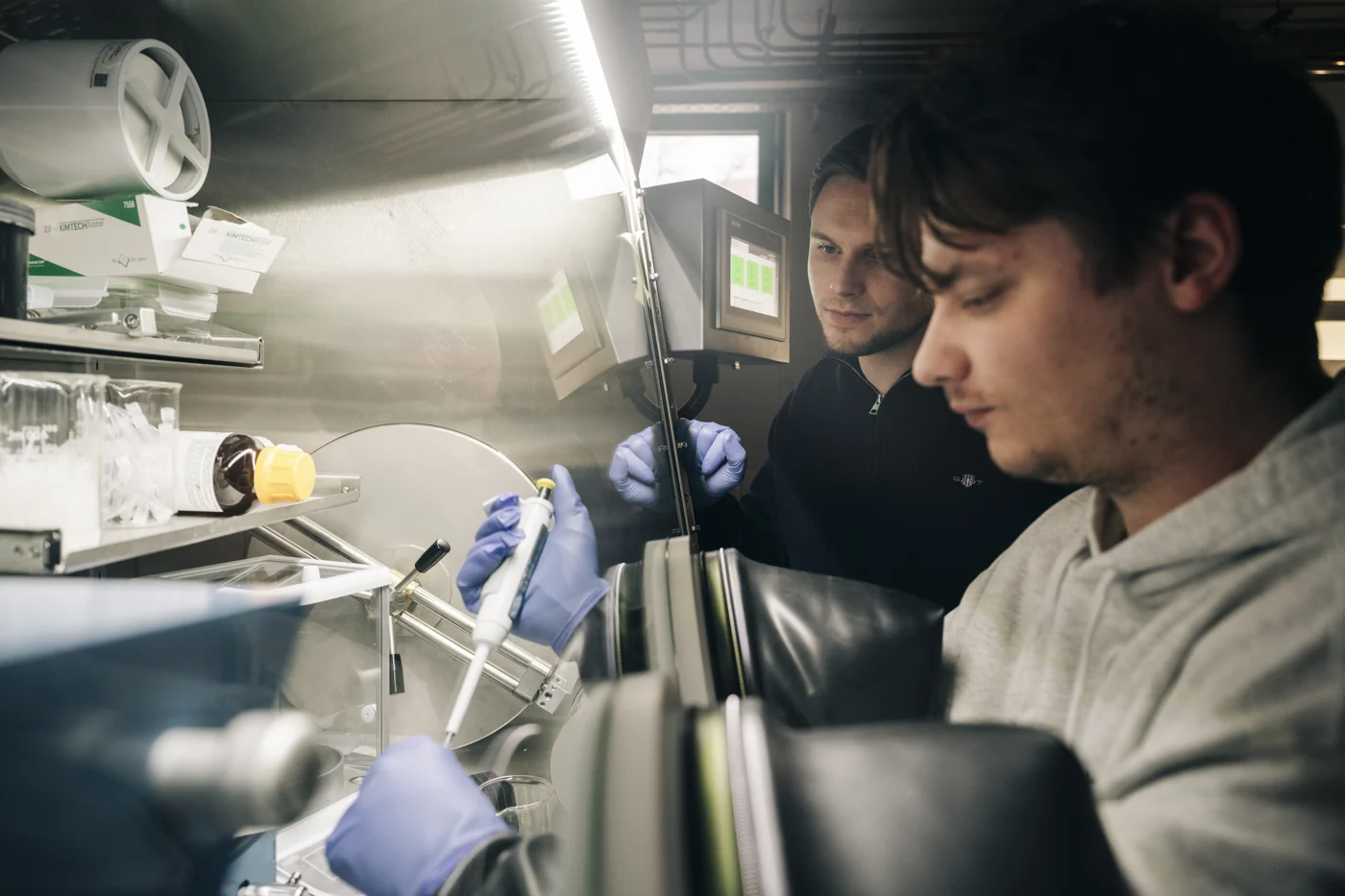 Working together at a glovebox in the lab.