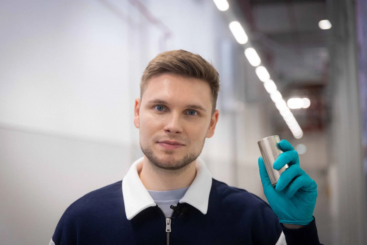 Tom Bötticher holding a battery cell in the lab.